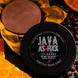 A coffee lotion bar is shown surrounded by coffee beans, oranges, and spices.