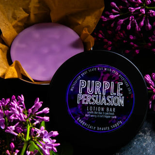 This lilac body lotion bar is shown surrounded by fresh lilacs and patchouli in a black travel tin.