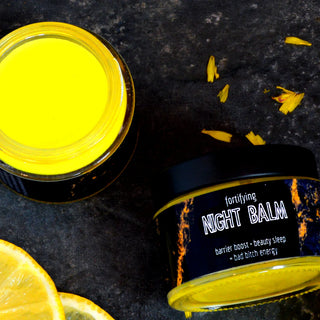 Rich turmeric night balm with mango, cocoa, and shea butter in a glass jar, surrounded by lemon and turmeric slices