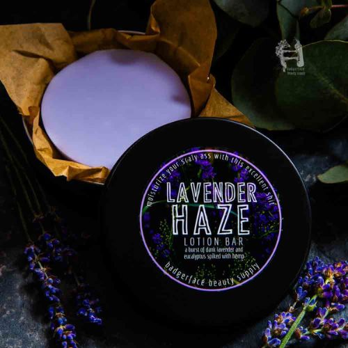 This Lavender lotion bar is shown in a black travel tin surrounded by fresh lavender.