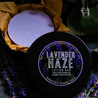 This Lavender lotion bar is shown in a black travel tin surrounded by fresh lavender.