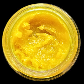Close-up of thick, buttery balm texture — golden turmeric glow with rich oils and plant butters