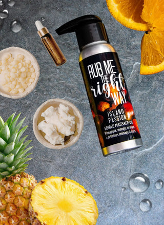 Tropical-flavored edible massage oil is shown surrounded by the natural ingredients it's made of in this image by Badgerface Beauty Supply.